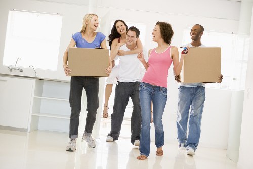 Removal team pricing a move from a compact flat with boxes and furniture