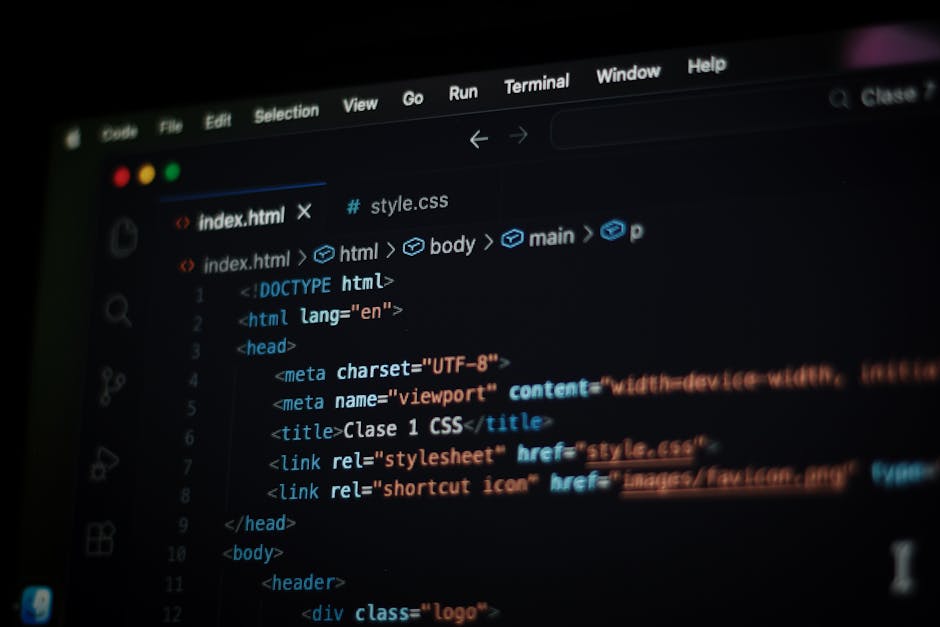Photograph of a computer screen displaying a code editor with an HTML document open. The code includes elements such as <!DOCTYPE html>, <html>, <head>, <title>, and <link rel='stylesheet'>, indicatin