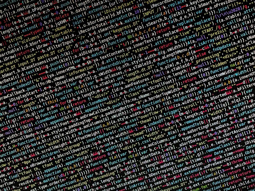 Photograph of a computer screen displaying a code editor with an HTML document open. The code includes elements such as <!DOCTYPE html>, <html>, <head>, <title>, and <link rel='stylesheet'>, indicatin